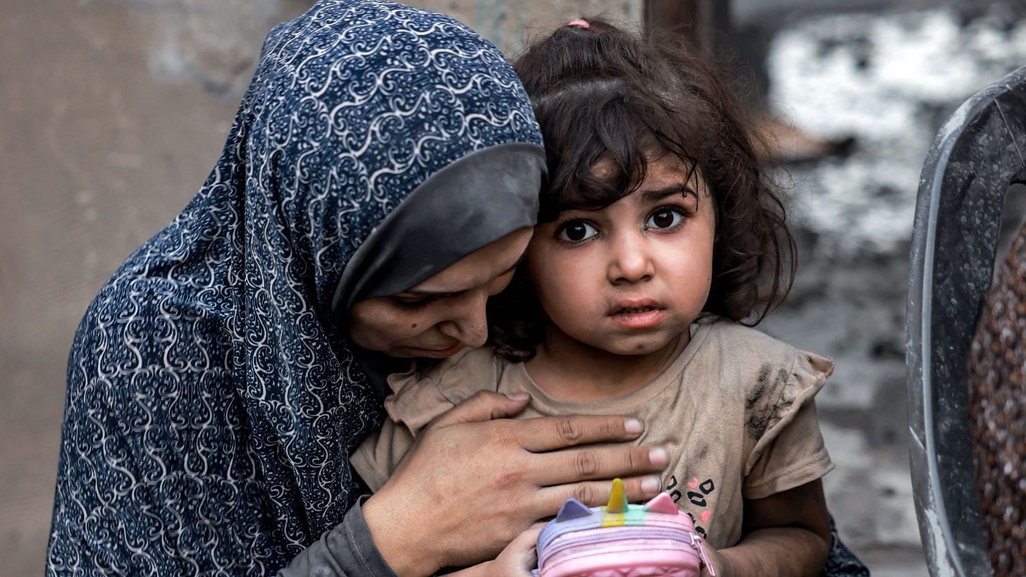 A Palestinian family sits near destroyed houses following a strike in Rafah on the southern Gaza Strip on November 6, 2023, amid the ongoing battles between Isreal and the militant group Hamas. (Photo by MOHAMMED ABED / AFP) (Photo by MOHAMMED ABED/AFP via Getty Images)