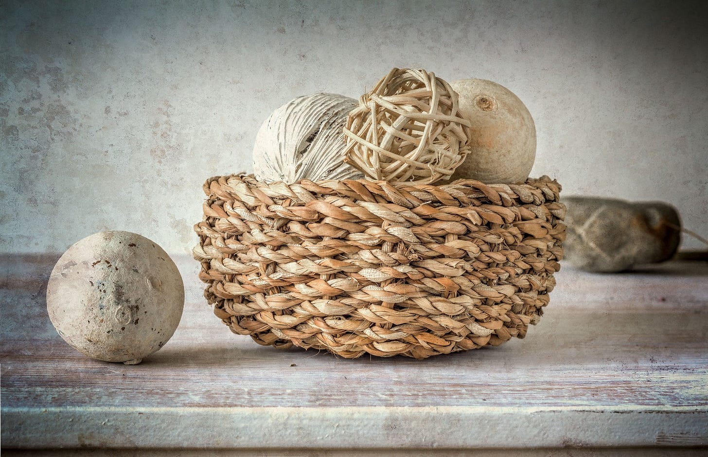 Textured, natural fibre balls in a rustic wicker basket on a table