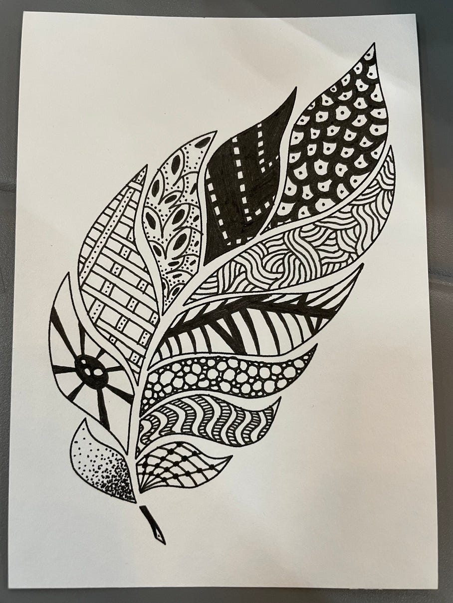 Photo of a black and white zentangle drawing in the shape of a feather