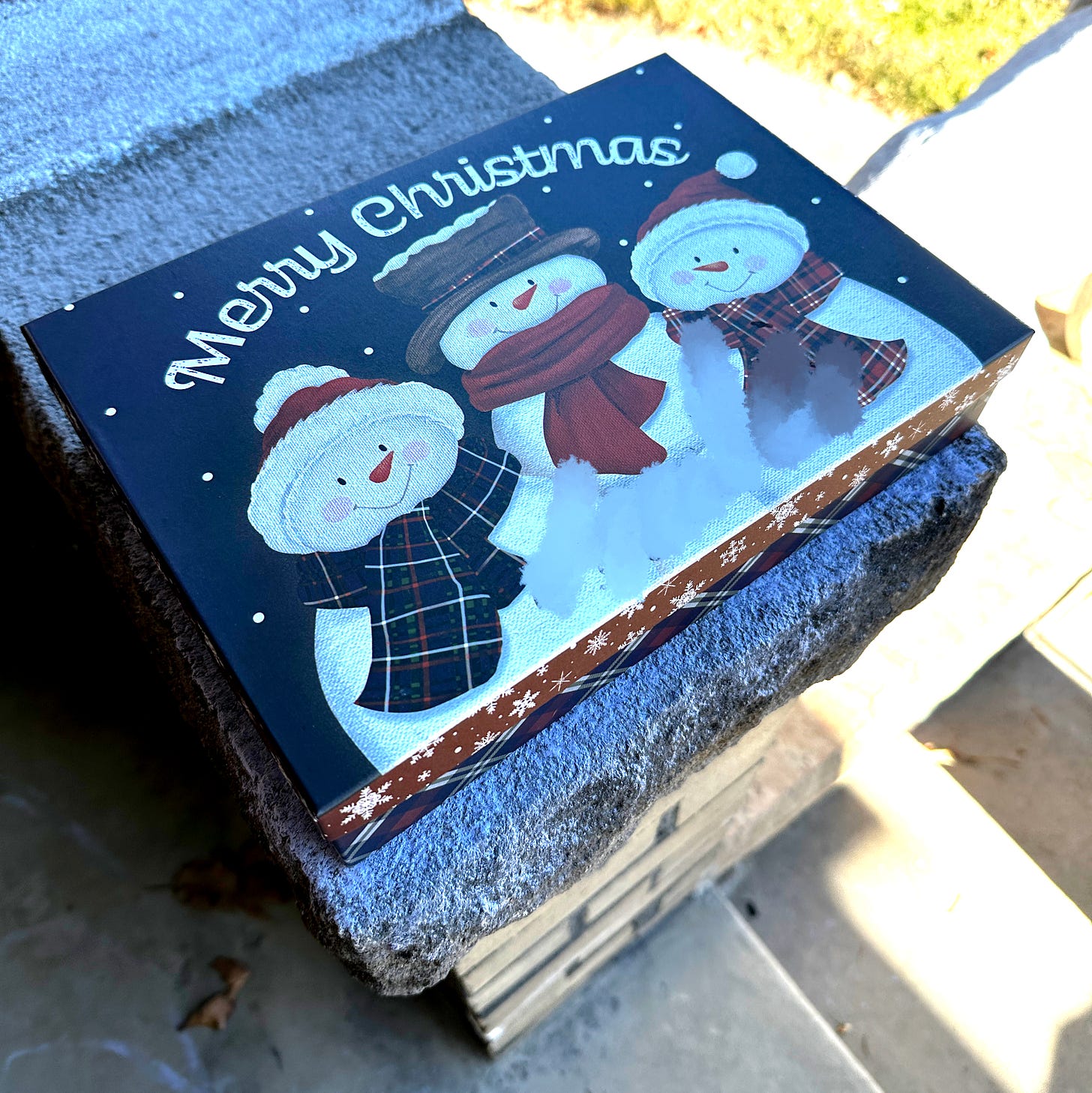 a box of cookies sitting on a front porch fence