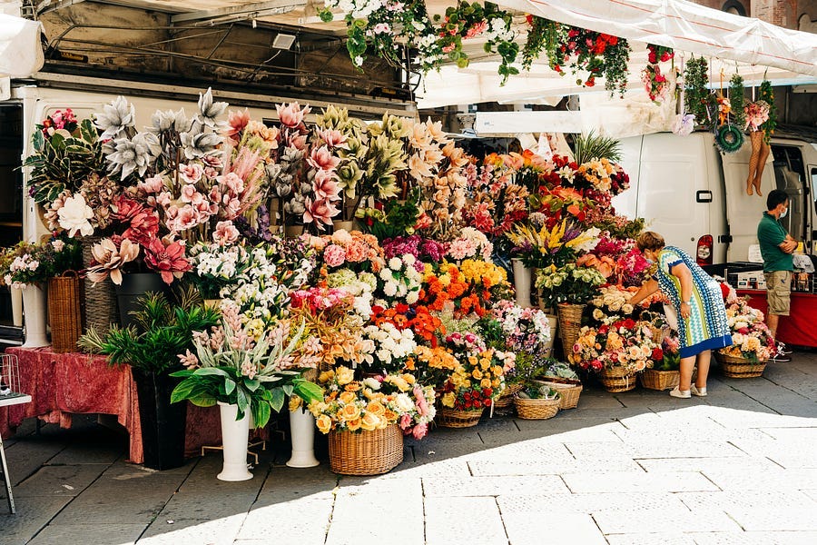 A stall with flower baskets on display.