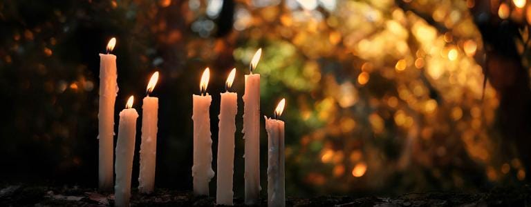 Burning candles in an autumnal forest
