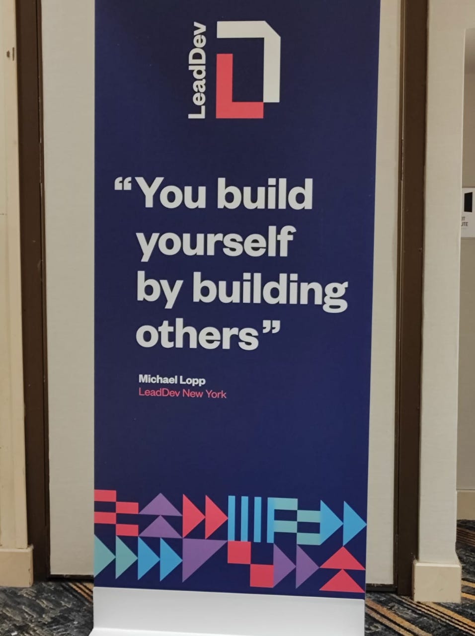 Exhibited poster a quote "You build yourself by building others" by Michael Loop from LeadDev New York.
