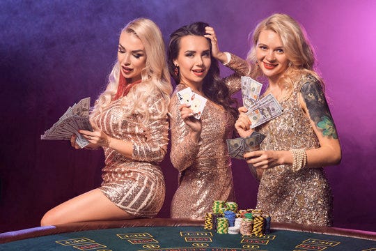Beautiful girls with a perfect hairstyles and bright make-up are posing  standing at a gambling table. Casino, poker. Stock Photo | Adobe Stock