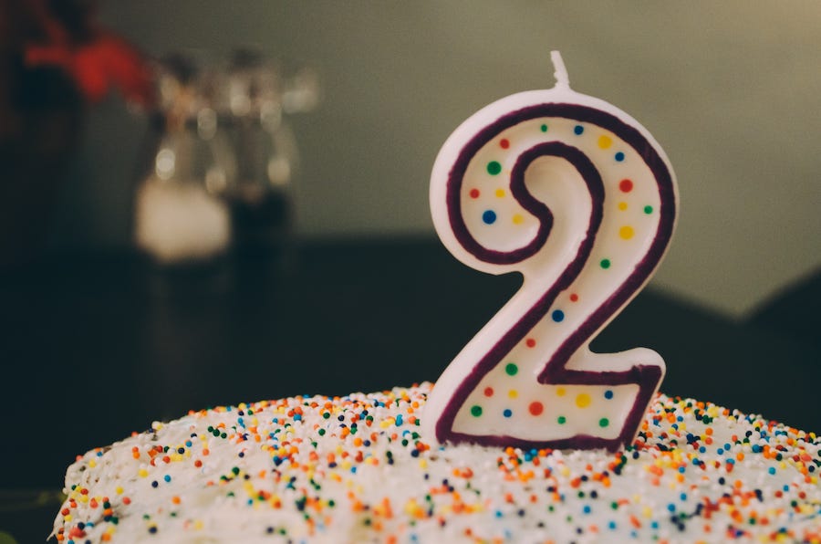 A birthday cake with a number 2 candle