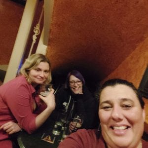 Three ladies under the stairs in the pub, with your author in the middle. Does this count as a snug? Sure.