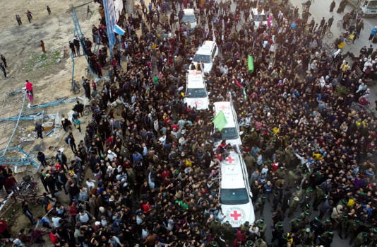  People gather as Hamas militants terrorists for the handover of hostages to the Red Cross in Gaza City, January 19, 2025