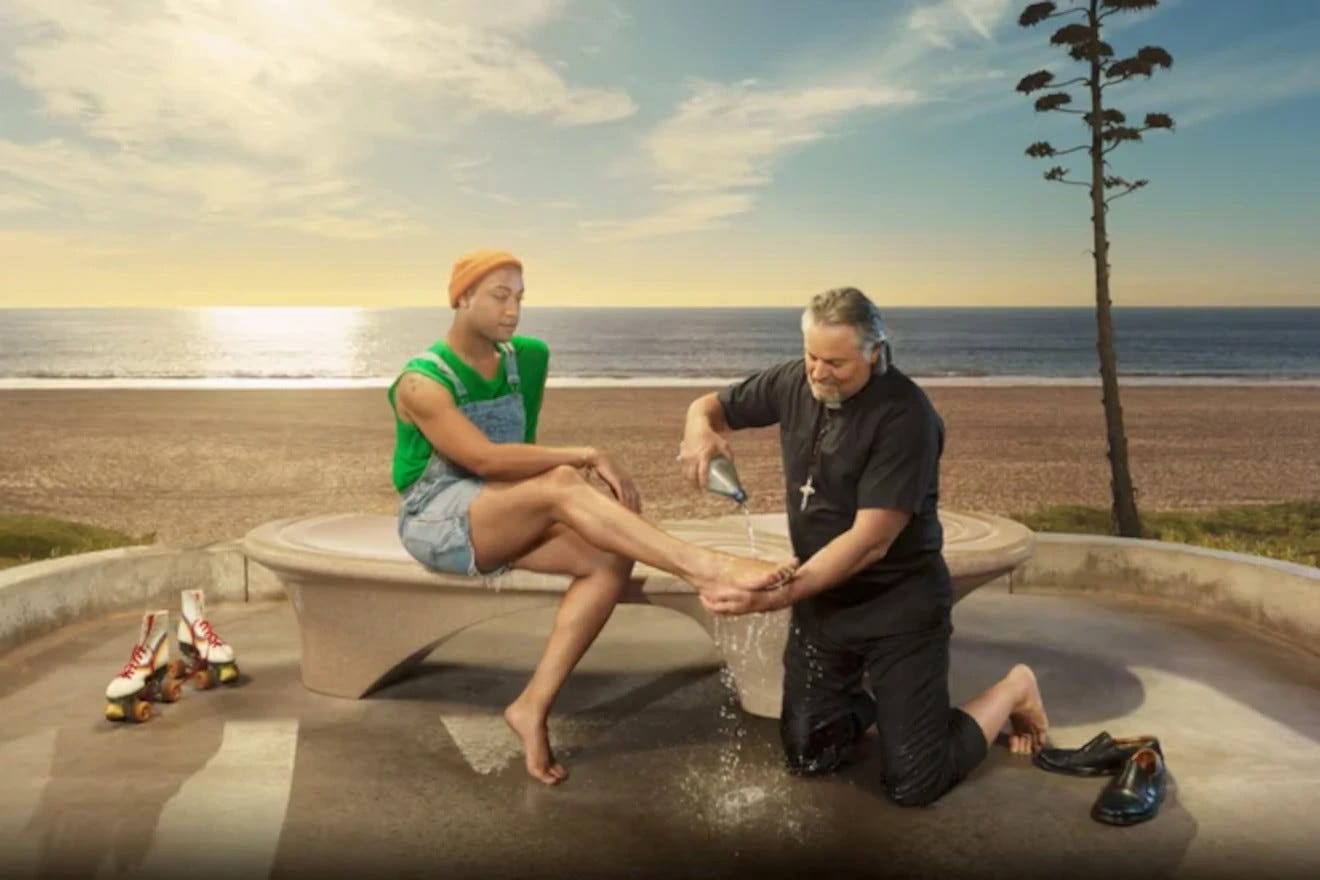A man dressed as a priest or pastor washes the fet of a roller-skater near a beach.