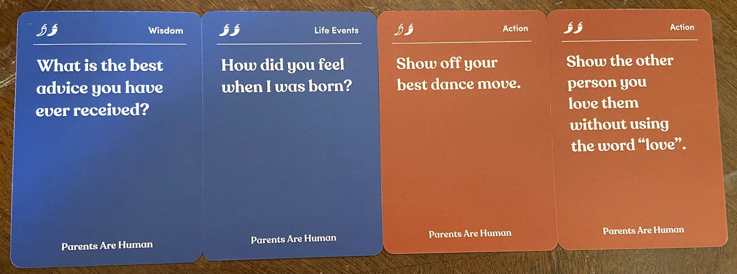 4 cards drawn from parents are human. First card says "What is the best advice you have ever received?" Second card says: "How did you feel when I was born?" Third card says "Show of your best dance move." and fourth card says "Show the other person you love them without using the word 'love.'"