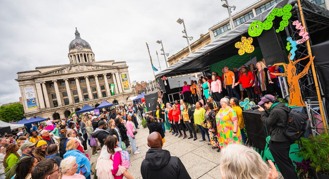 Nottingham's Old Market Square with a crowd of people standing in front of a black stage