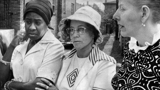 Linda Taylor, center, outside a home that she contends was...