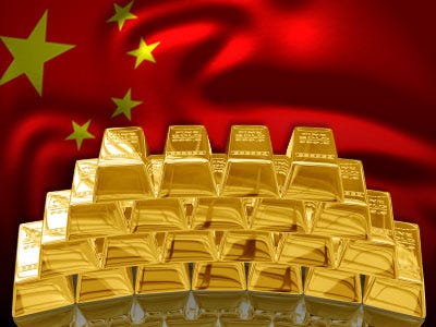 picture of Chinese flag behind piles of gold bars