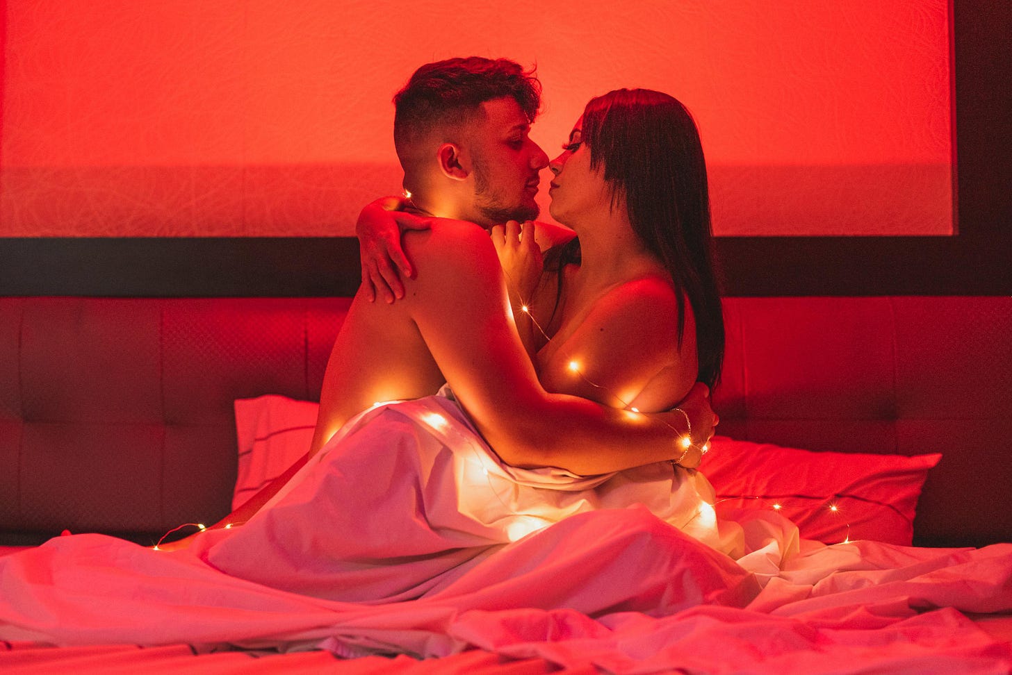 Couple embracing in bed with special lighting