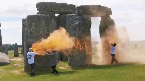 Just Stop Oil Orange clouds of paint being sprayed at Stonehenge