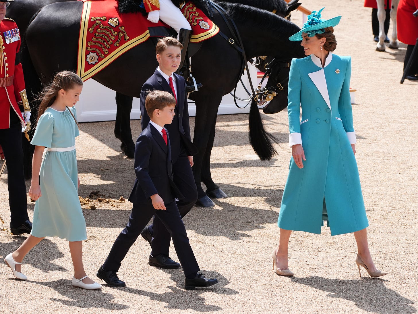 Princess of Wales wearing teal coat and walking in front of children