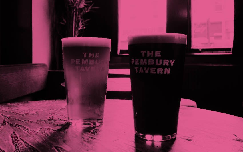 A pint of bitter and a pint of porter on a pub table.