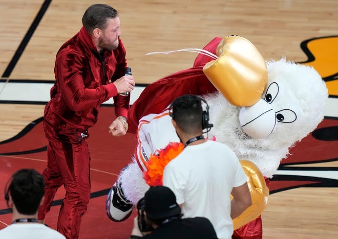 MMA fighter Conor McGregor takes a swing at Burnie, the Miami Heat mascot, during a break in Game 4.