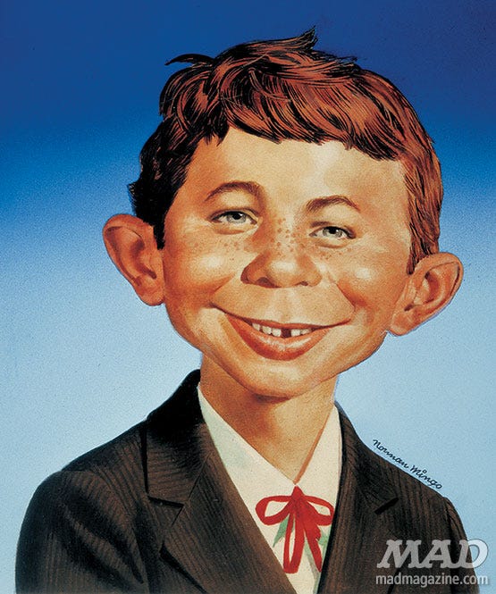 This is a photo of Alfred E. Neuman, the famous freckled, redheaded kid mascot with a missing tooth and a grin. he's wearing a cute lil suit and the signature has Norman Mingo's name and Mad Magazine as a watermark, which means i might get in trouble for using this pic. safer to ask forgiveness than permission???
