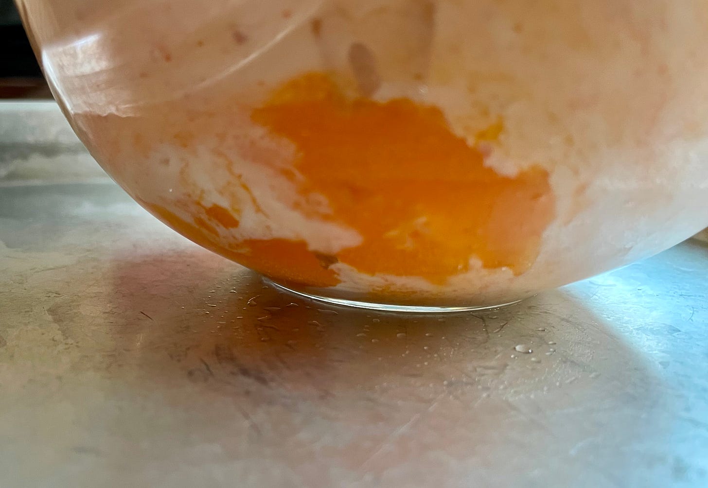 a clear bowl shows the Jell-O isn't mixed in well with the whipped topping