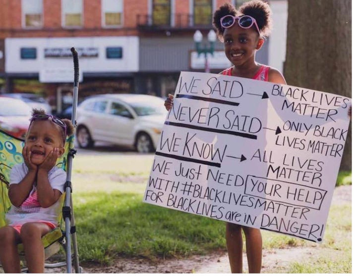 Girl holding sign that says "We said Black Lives Matter. We never said ONLY Black Lives Matter"