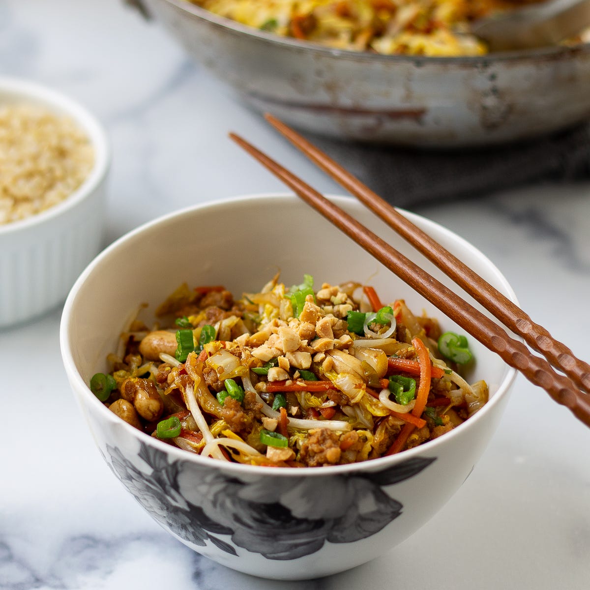 A bowl of cabbage and crispy pork stir fry with brown sauce. 