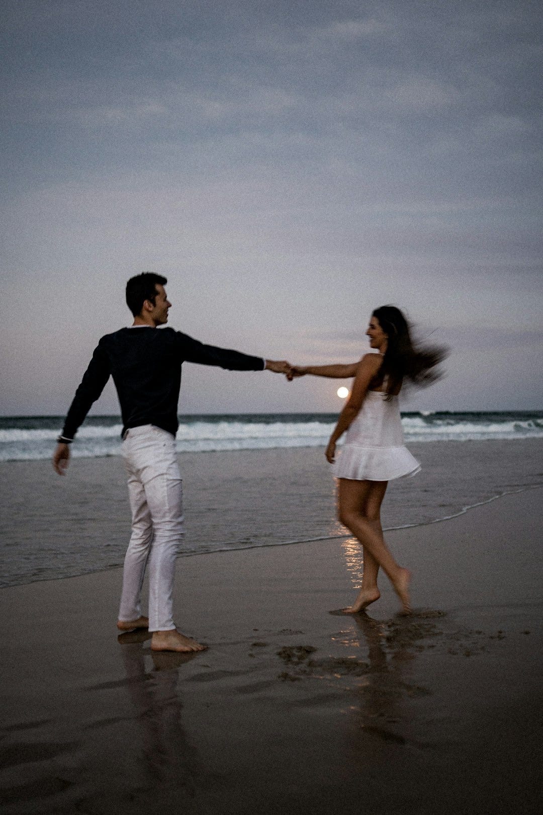 a man and a woman holding hands on a beach a man and a woman holding hands on a beach