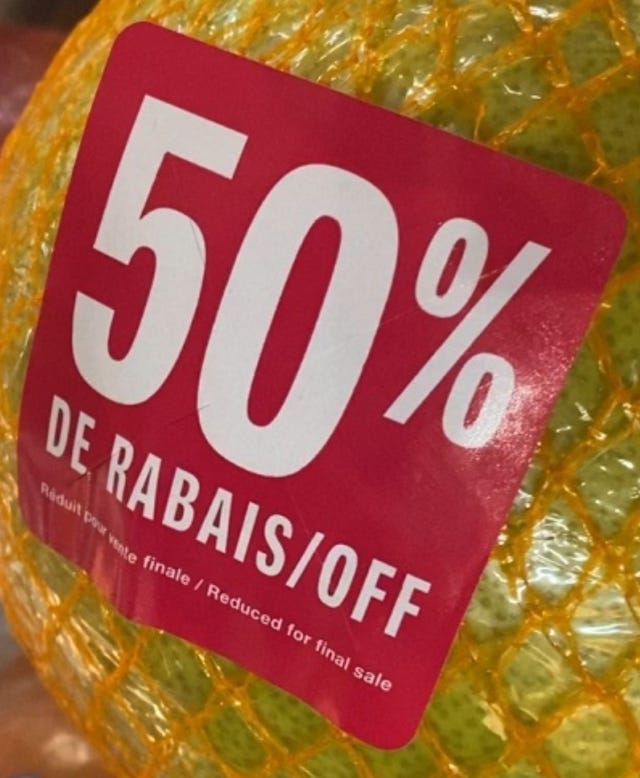 Close-up of a 50% discount label on a nearly expired piece of fruit.