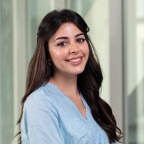 Photo of a smiling young woman with long dark brown hair wearing a blue blouse Photo of a smiling young woman with long dark brown hair wearing a blue blouse