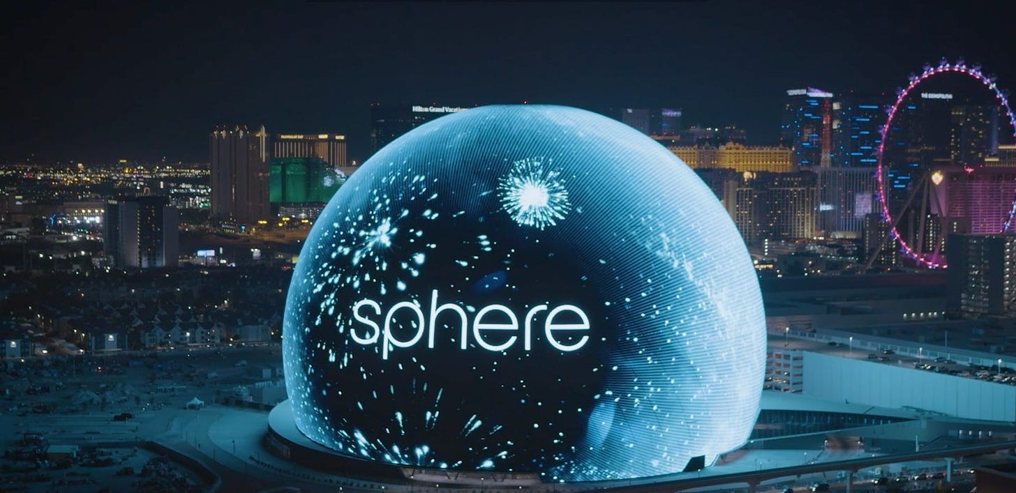 The Vegas sphere at night, looming over the city with the word "sphere" on it