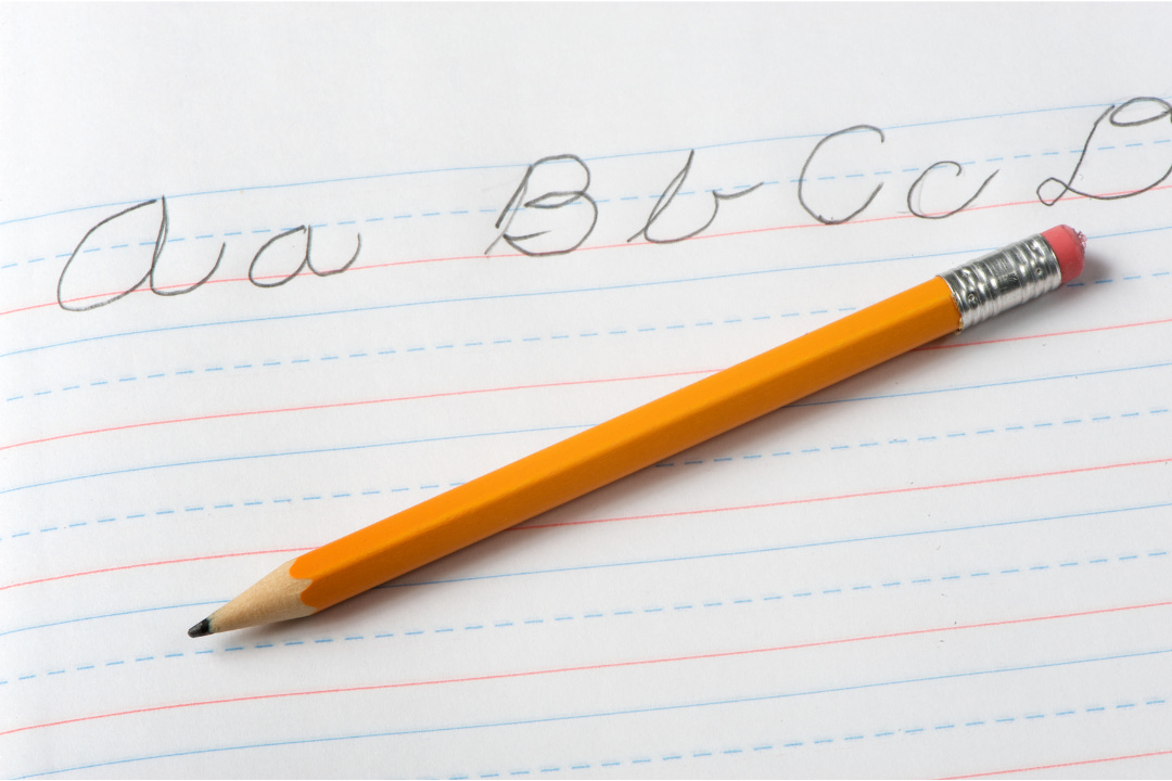 simple cursive handwriting practice on a page of notebook paper with a pencil