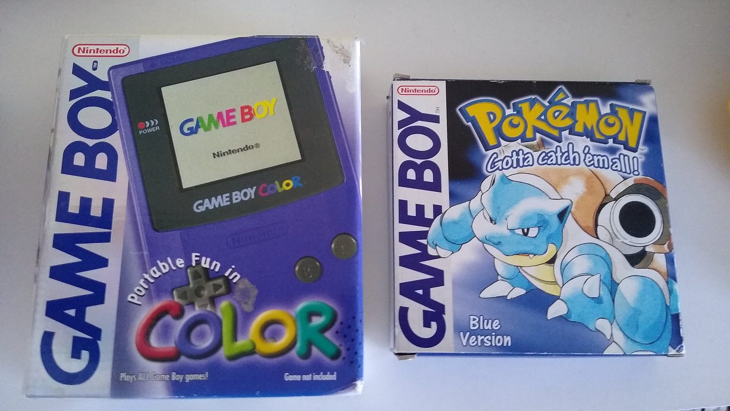 A photograph of a Game Boy Color and a copy of Pokémon Blue