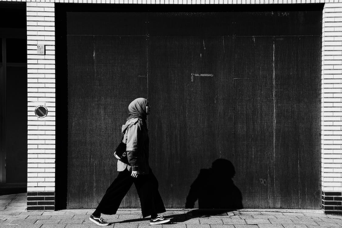 Free A Woman Walking on the Sidewalk  Stock Photo