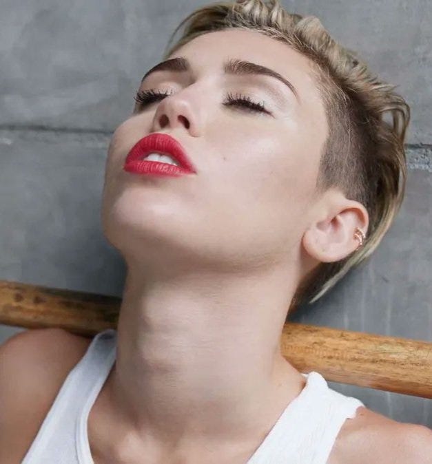 An image of Miley Cyrus with her head back, her trachea pronounced.