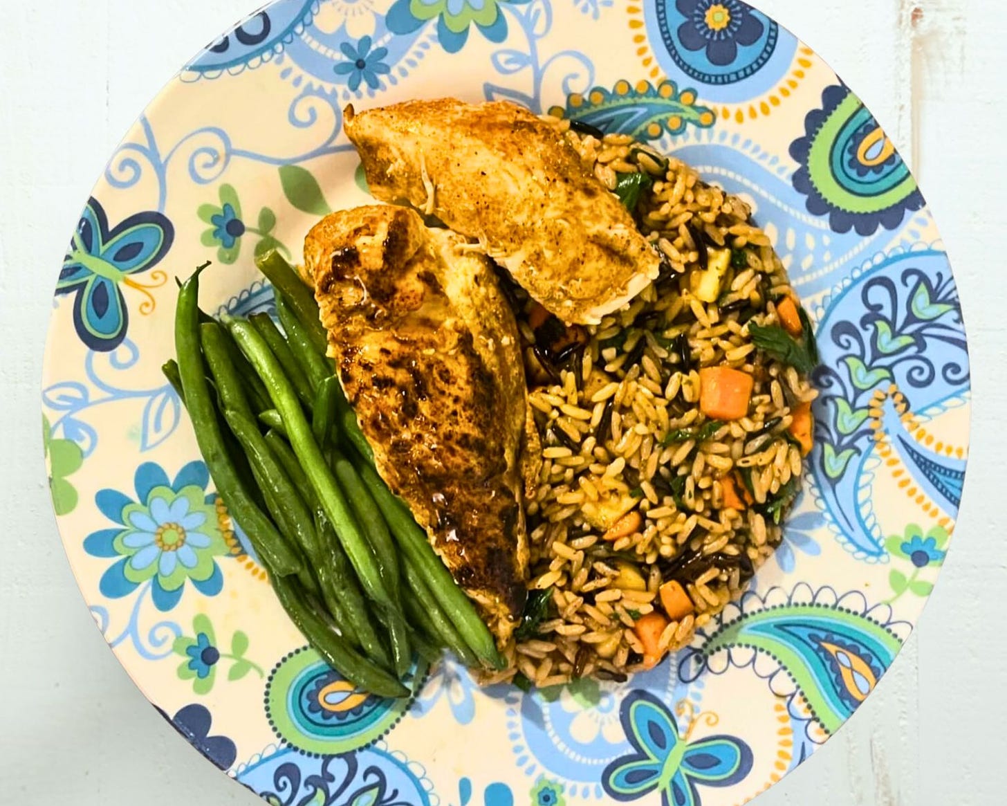 Dinner plate with pan-seared chicken breast, haricot vert, and vegetable wild rice