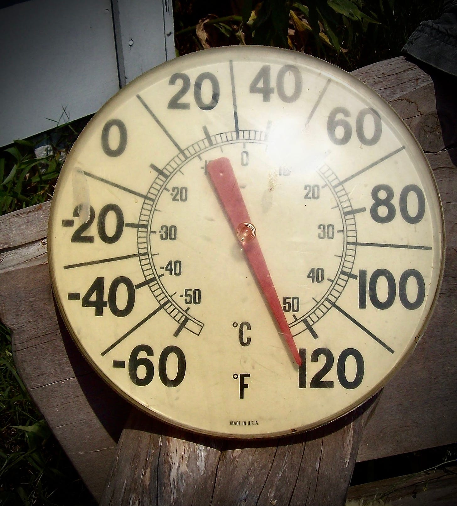 image of an old, round thermometer with the red dial pointing at 120 degrees