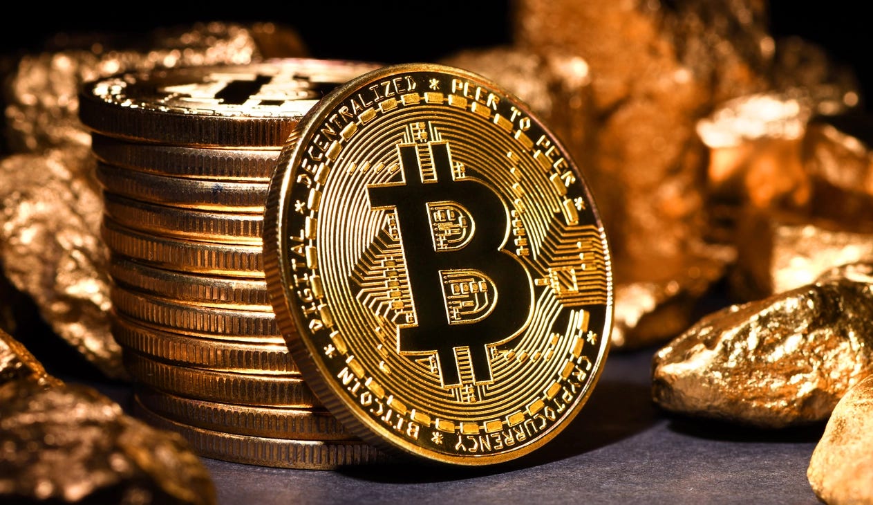 Monedas de Bitcoin junto a oro