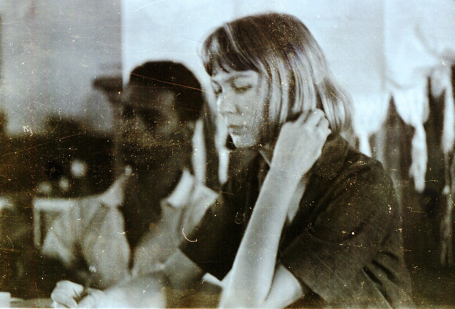 Woman with short hair sitting with her hand on her face