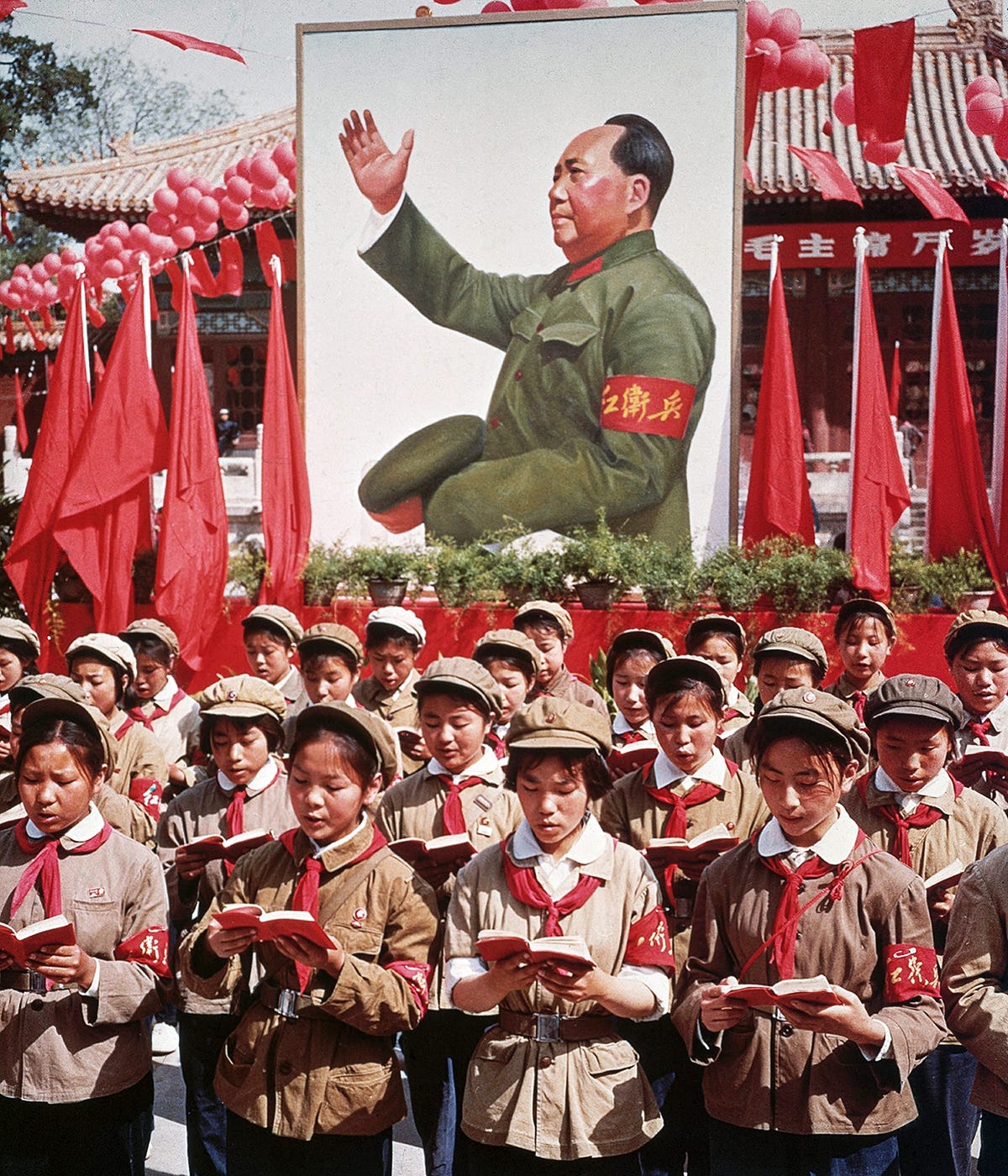 A group of children in uniform in front of a picture of Chairman Mao Zedong  holding Mao's 'Little Red Book' during the Cultural Revolution, circa 1968  [1200x1400] : r/HistoryPorn