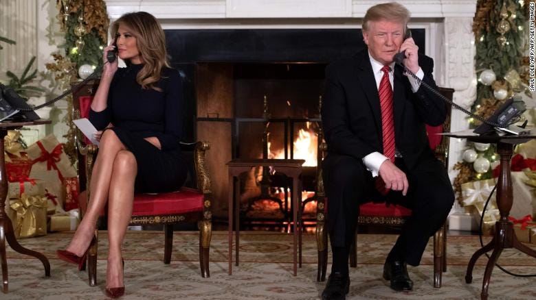 President Donald Trump and First Lady Melania Trump answer calls from people calling into the NORAD Santa tracker phone line at the White House on December 24, 2018. 