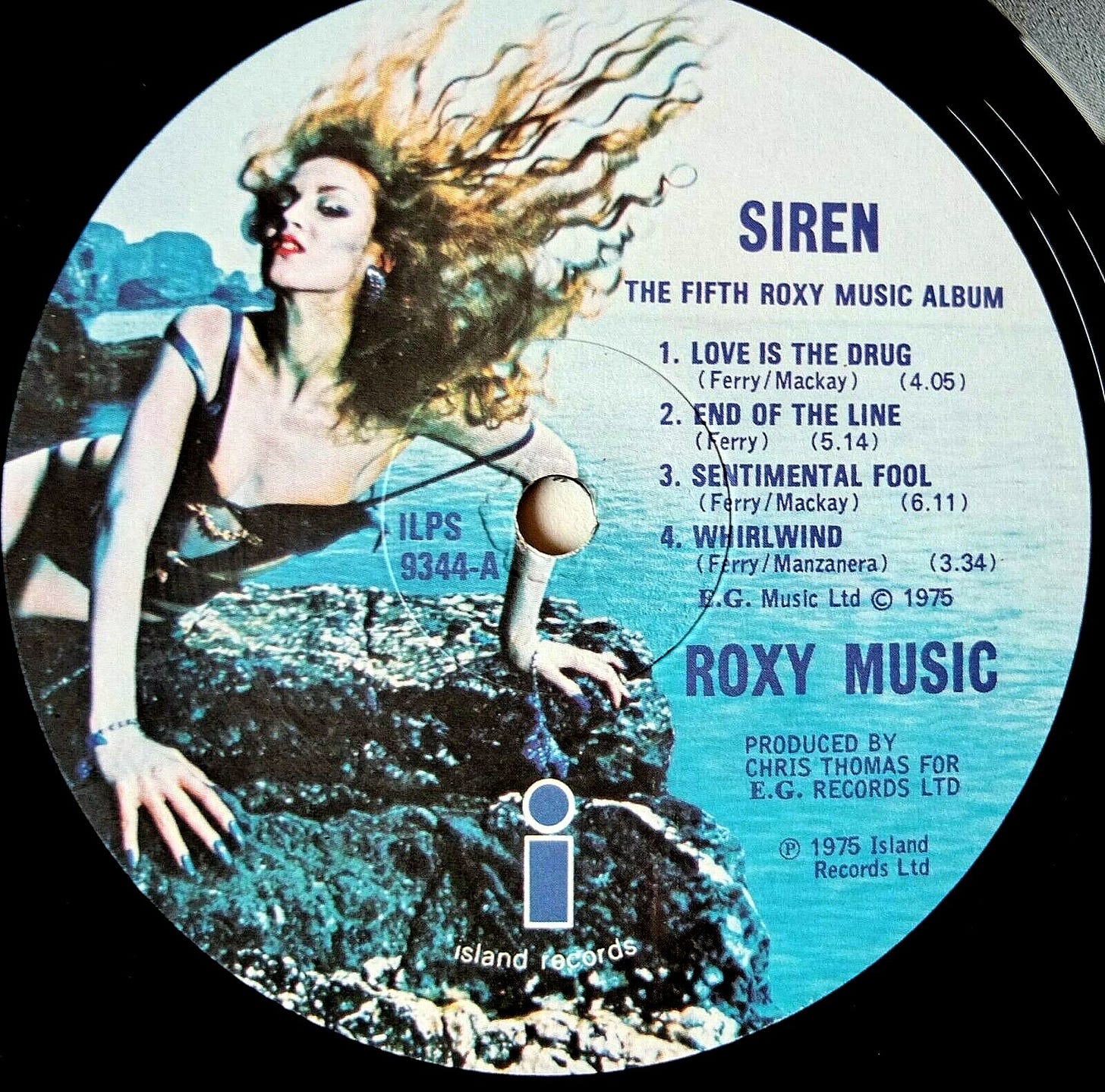 The center label of an LP of Roxy Music's album "Siren." A beautiful woman, her hair flying, is poised on a rock. Text on the label says, "The Fifth Roxy Music Album," followed by a list of songs: "Love Is the Drug," "End of the Line," "Sentimental Fool," and "Whirlwind." The record is copyrighted in 1975. 
