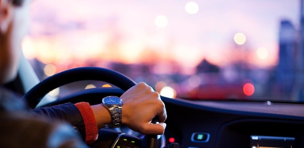 man driving a car wearing wrist watch