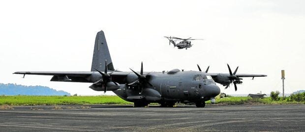 US AIR ASSETS An AC-130J Ghostrider aircraft is parked at Subic Bay International Airport. Flying above it is a CH-53 helicopter. Both were brought to the Philippines for “Balikatan” 2023. —LYN RILLON