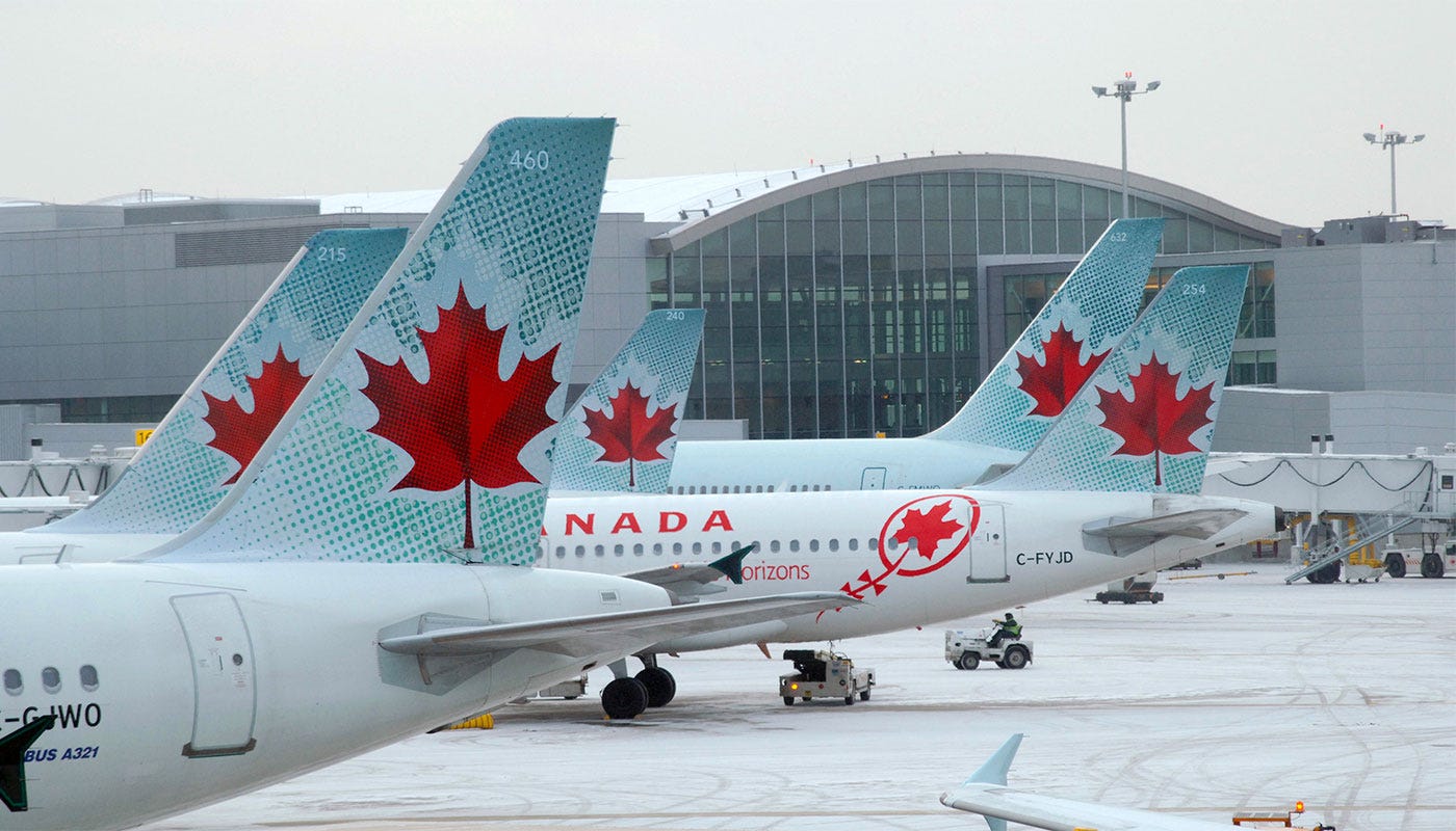 Air Canada airplanes parked at the airport in the wintertime with snow on the ground.