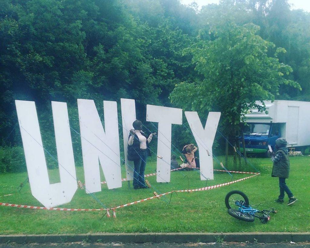 Tall wooden letters spell out UNITY at Peace in the Park in the Ponderosa, Sheffield