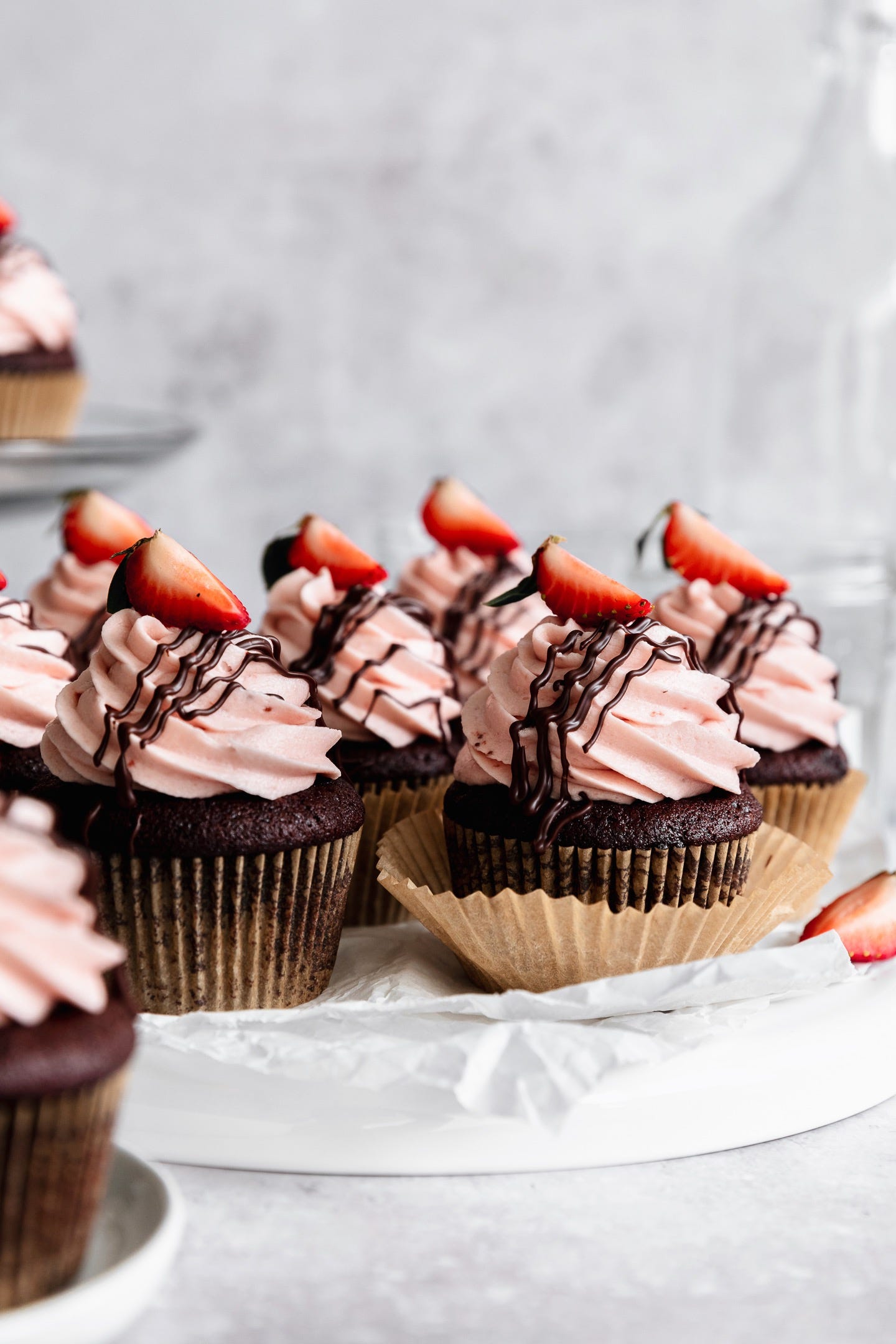 Vegan chocolate-dipped strawberry cupcakes on a white plate