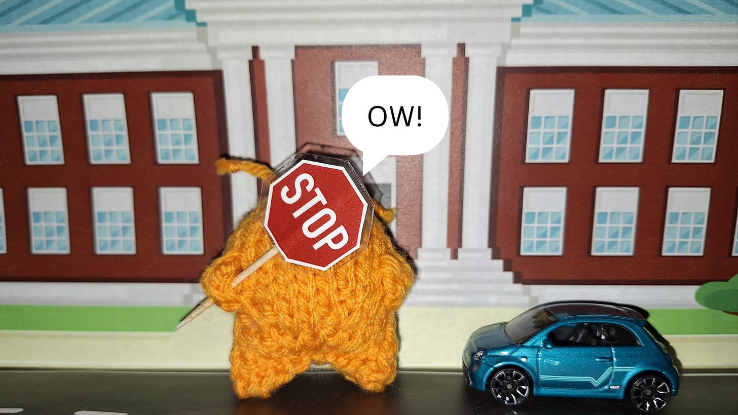 knitted alien with stop sign in front of his face near a car. text bubble reads ow.