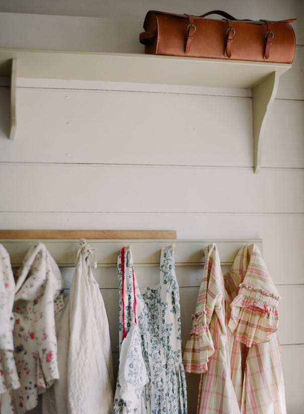 robes hanging from hooks along a white wood wall