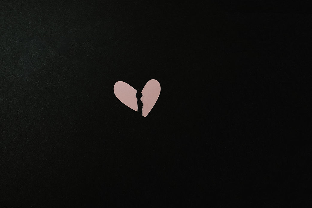 Black image with light pink broken heart in the centre.