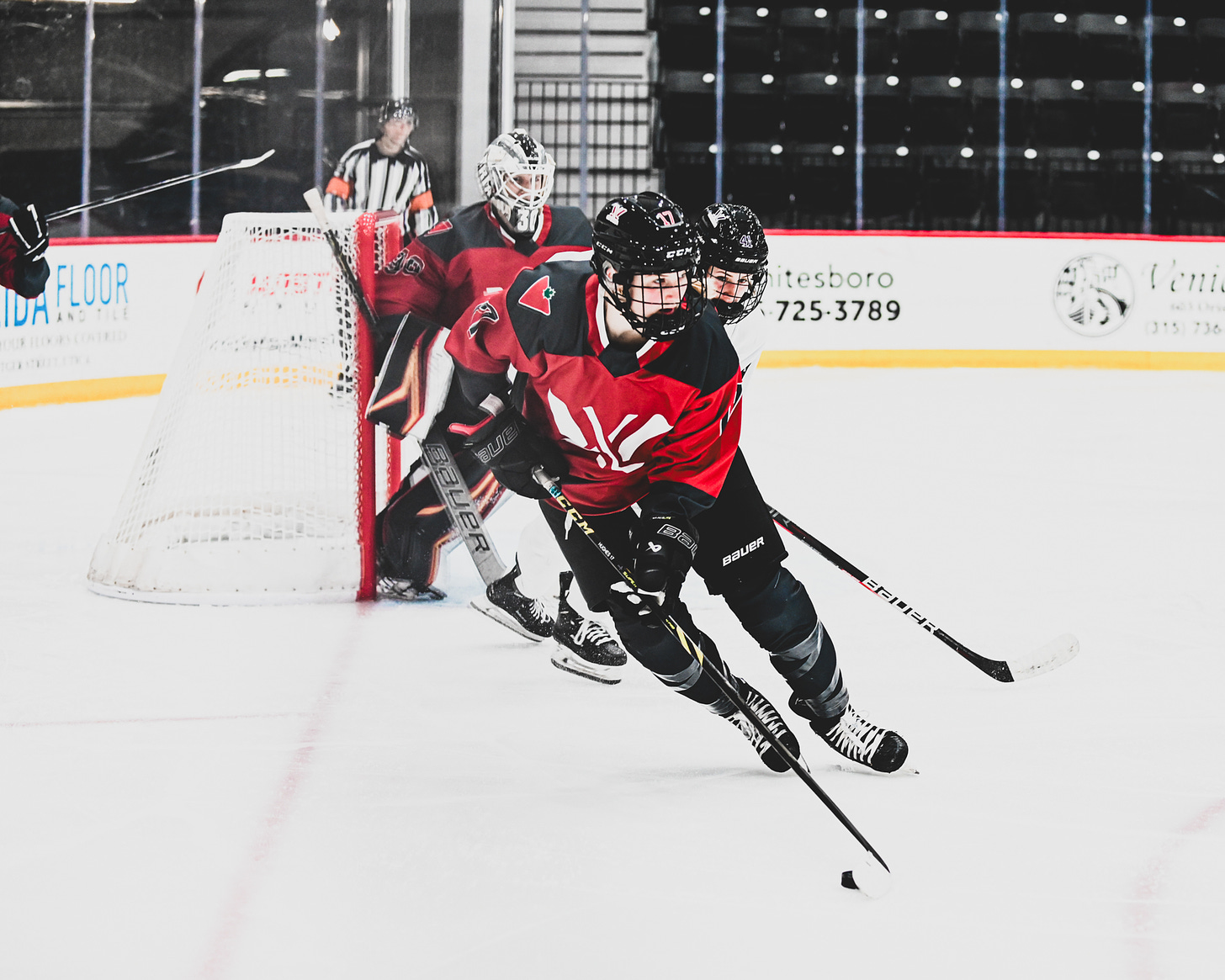 Savannah Harmon, Gabbie Hughes, Hayley Scamurra all skating during a game.