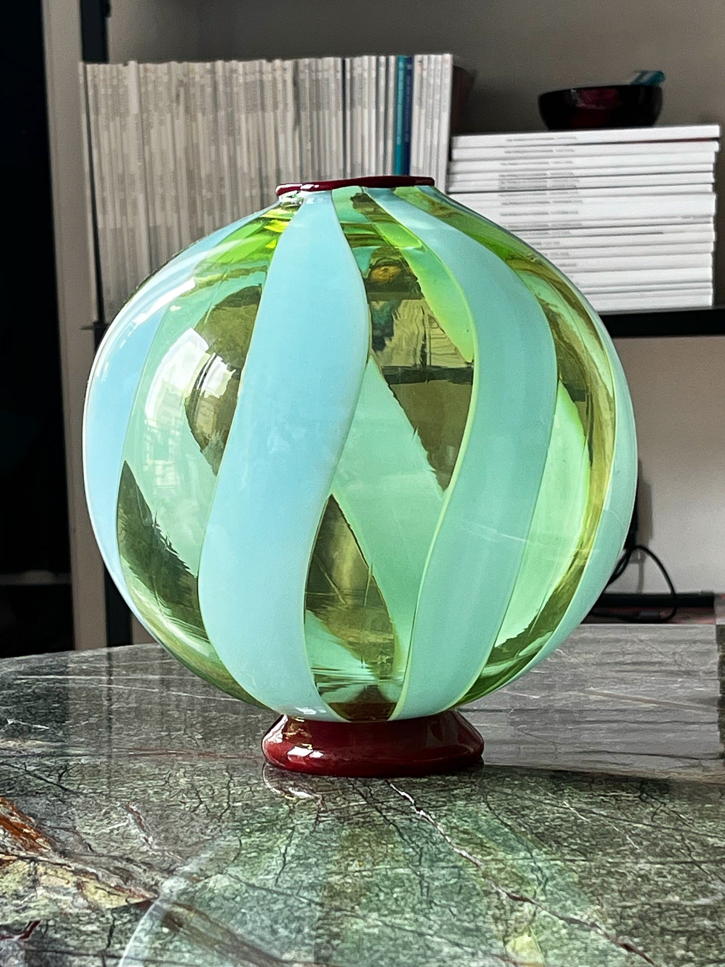 Blown Murano glass vase in teal and green sitting on a counter